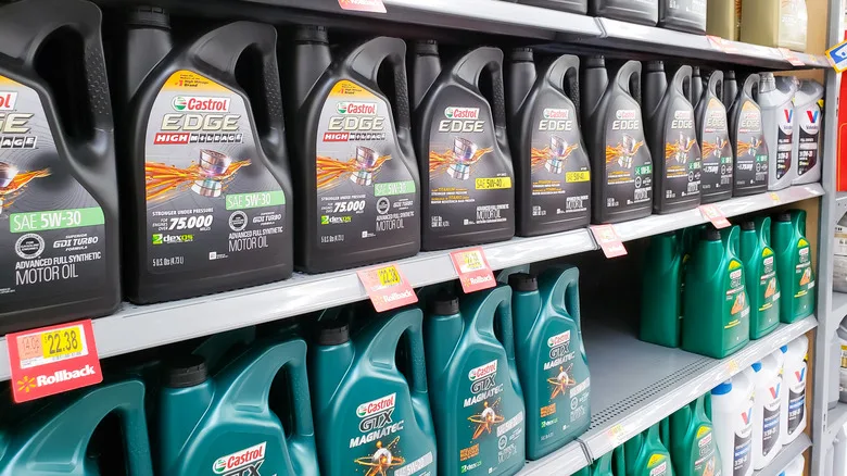 Bottles of various synthetic motor oils on a shelf, showing different brands and viscosities
