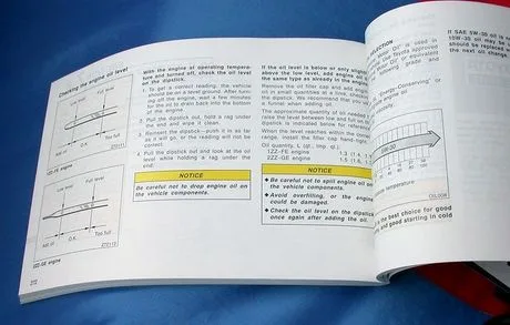 person pointing to a section in a car’s owner’s manual about fluid specifications