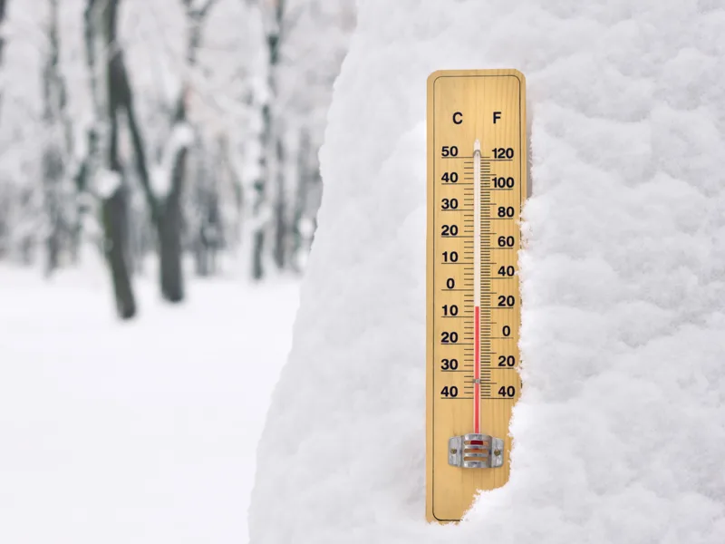 thermometer showing very cold temperatures next to a bottle of gear oil